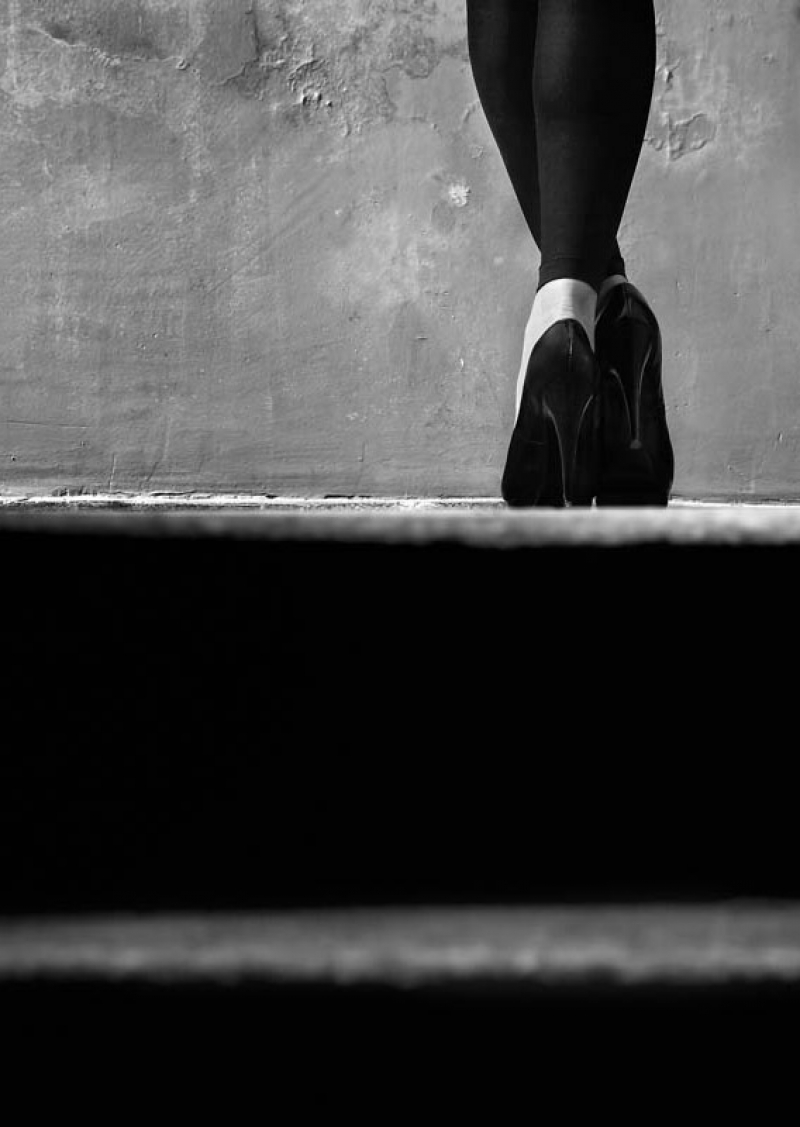 Feet girl in shoes standing on the top step.